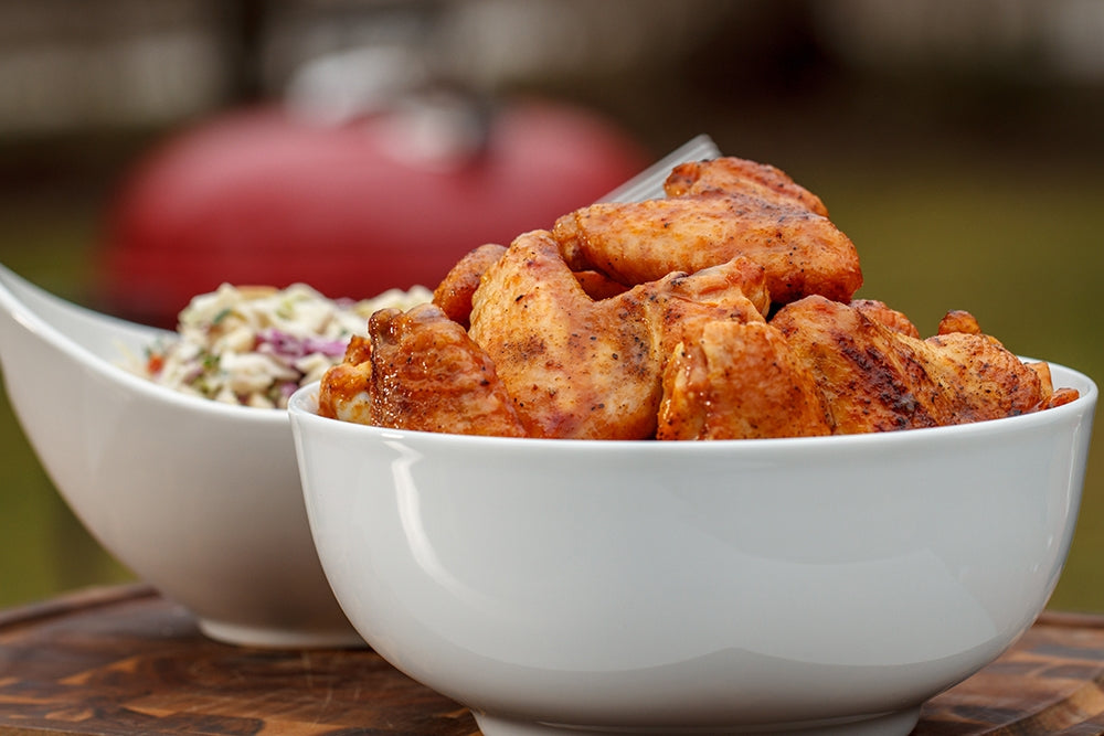 Bowl of grilled chicken wings from a charcoal grill and coleslaw on the side – Tailgating 101 – Weber Grills