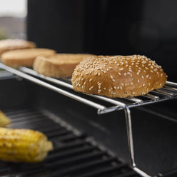 The warming rack keeps food warm or toasts buns while the main course grills below.