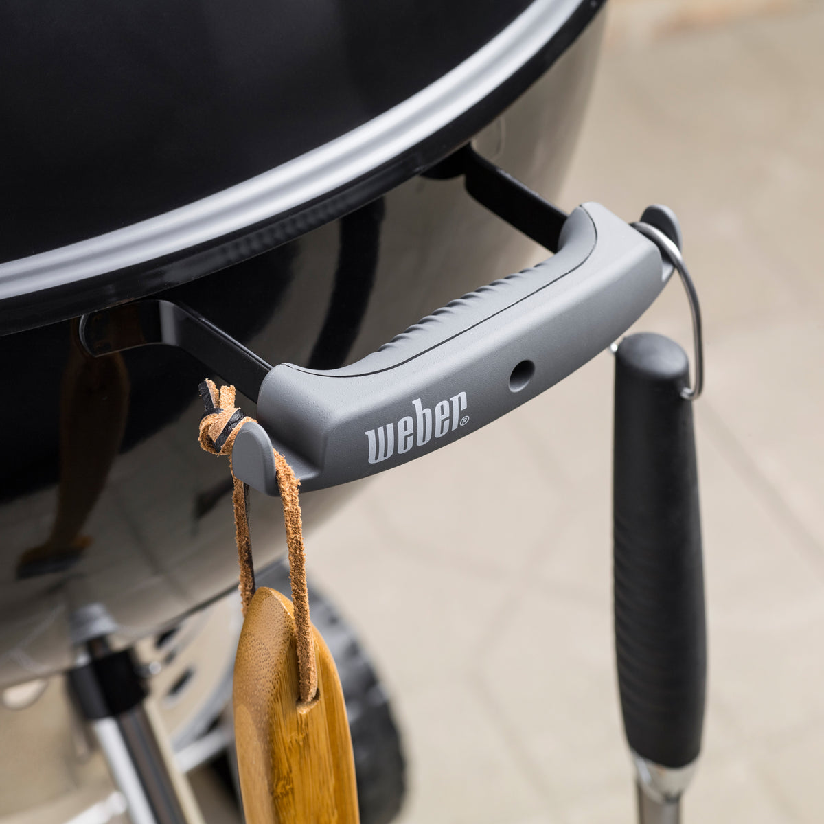 Bowl handle tool hooks on the black Weber 22” Original Kettle Premium charcoal grill keep grilling utensils within reach.