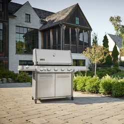 Weber Summit FS38 S gas grill brings outdoor cooking to a backyard patio with side shelves for prep and serving.