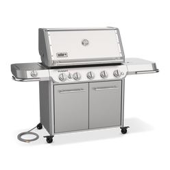 Angled view of the stainless steel Weber Summit FS38 S gas grill with a closed lid, covered side burner, double-door storage cabinet, and natural gas hose.