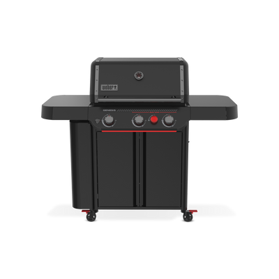 Front view of the matte black Weber Genesis E-330 Gas Grill Stealth Edition with the lid closed, a built-in thermometer, two side tables, enclosed storage, and a red Sear Burner knob.