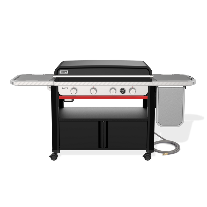 Front view of the Weber Slate 36” Rust-Resistant Griddle with the hard cover closed, four control knobs, a digital thermometer, side tables and lower storage cabinets.