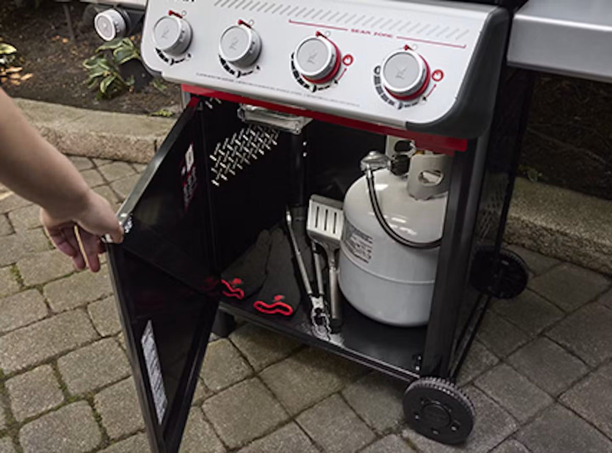 Cabinet with door hides the propane tank and grilling accessories.