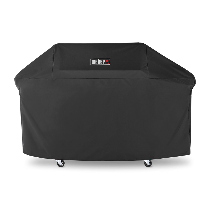 A centered Weber logo marks the black Premium Grill Cover, fitted over a Genesis grill’s lid, side tables, and cabinet with the casters exposed below.