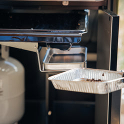 Removable drip pan in the Weber Genesis S-435 Gas Grill collects grease for easy disposal and replacement during cleanup.