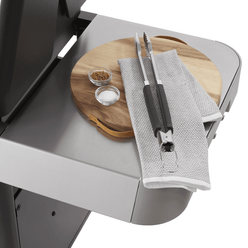 Extra-large prep and serve table keeps a cutting board, seasonings, and tongs within reach.
