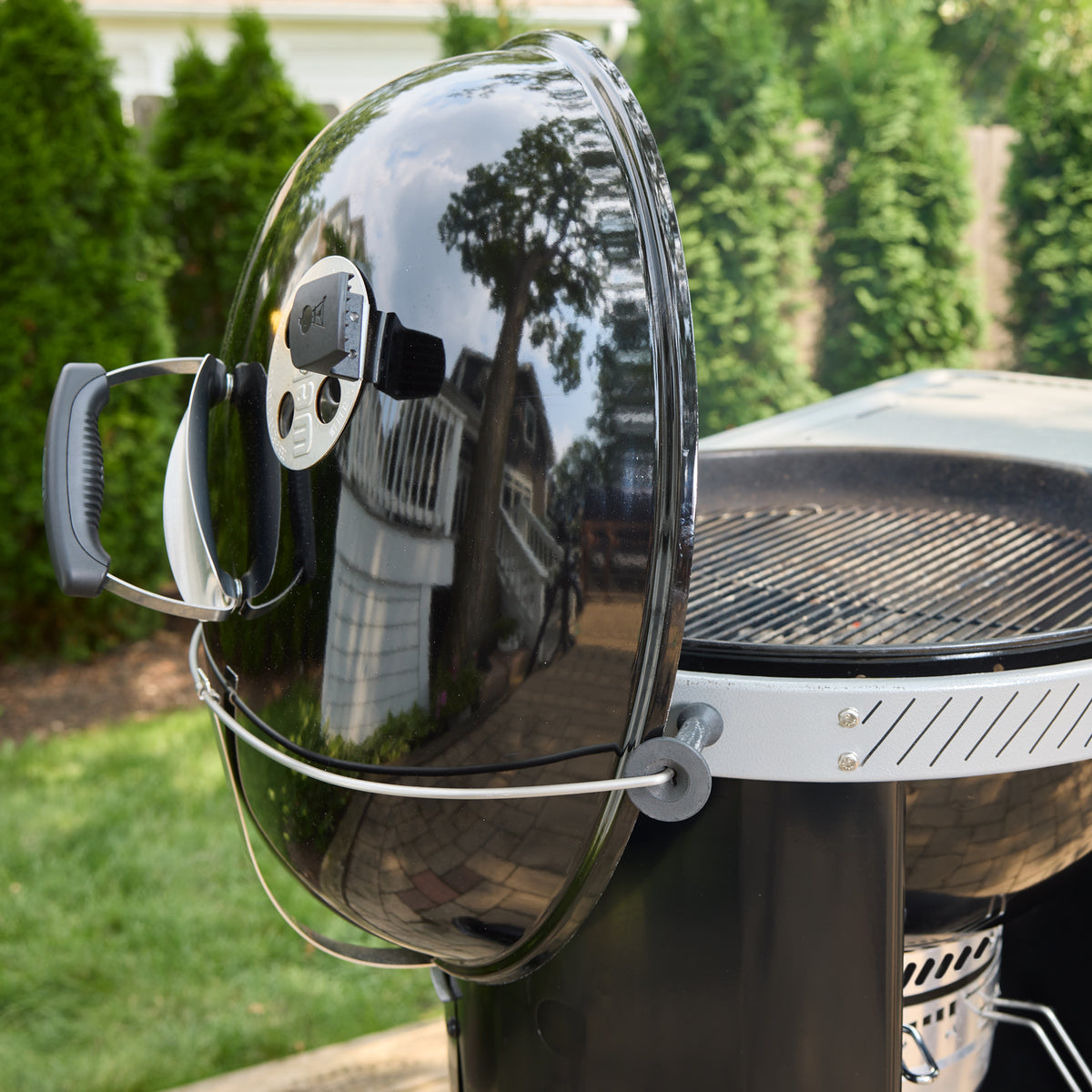 Tuck-Away lid holder keeps the lid off the ground and out of the way while grilling.