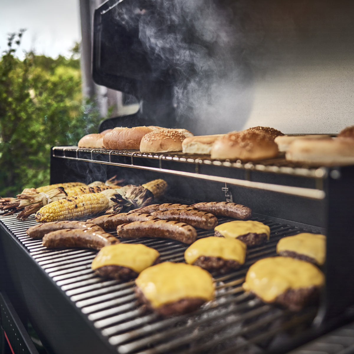Cook burgers and sides on the main cooking surface and toast buns on the warming rack. 